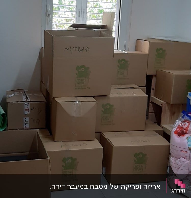 קופסאות קרטון מסודרות בערימה ליד חלון